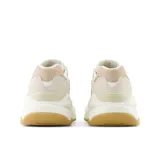 Championes New Balance modelo 5740, color crema con detalles en beige y suela caramelo. Confeccionados en gamuza y malla, con logo "N" característico en los laterales y entresuela con detalles moteados.