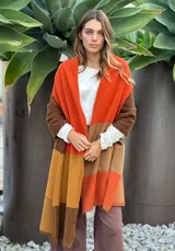 Pashmina de lana con diseño de bloques de color en gris oscuro, gris claro, blanco y negro. Presenta costuras decorativas en contraste.