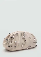 Bolso de mano tipo clutch, confeccionado en piel caprina color beige, con diseño fruncido y adornado con pequeñas esferas metálicas plateadas distribuidas por toda la superficie.