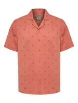 Camisa de manga corta RKF con cuello cubano, confeccionada en Tencel. Presenta un estampado sutil de motivos marinos sobre un fondo color salmón y cierre frontal con botones.