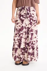 Pollera larga de viscosa con diseño escalonado y estampado estilo animal print abstract en tonos bordó y beige, con cintura elástica y cordón ajustable.