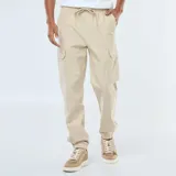 Pantalón cargo color beige, de corte estándar, con múltiples bolsillos laterales y cintura elástica con cordón ajustable.