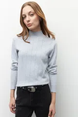 Polera de tejido de punto con cuello alto y diseño de rayas verticales sutiles. Presenta un ajuste al cuerpo y mangas largas.
