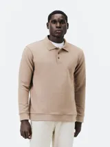 Polo manga larga color beige en tejido piqué, corte regular, con cuello clásico y tapeta de dos botones.