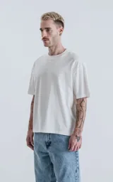 Remera de algodón premium color blanco tiza, con corte crop, calce oversize, hombros caídos y cuello redondo.