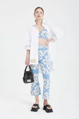 Pantalón celeste con estampado floral en blanco, corte cropped y tiro alto.