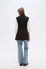 Chaleco largo de corte recto y diseño abierto, con solapas clásicas y bolsillos laterales. Confeccionado en poliéster, presenta una caída fluida y un estilo versátil ideal para superposiciones.