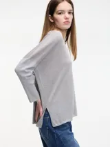 Sweater negro de hilo con textura brillosa, escote en V y manga larga.