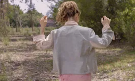 Chaqueta color beige con estampado abstracto en tonos amarillos, con cuello camisero, cierre frontal con botones, bolsillos plaqué y puños camiseros.