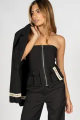 Top negro tipo corset, sin mangas, con cierre frontal metálico, bolsillos tipo cargo y etiqueta con la inscripción "Craft Punk" en el lateral.