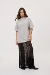 Remera oversized de manga corta y cuello redondo, de color negro con efecto acid wash y aplicación de strass en la parte superior.