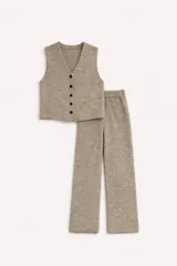 Conjunto de dos piezas confeccionado en tejido de punto color beige melange. Incluye un chaleco con escote en V y cierre frontal de botones, y un pantalón de corte recto con cintura elástica.