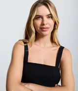 Blusa peplum de bengalina color negro, con escote recto y breteles anchos. Presenta un corte ajustado en el torso con un dobladillo con volados que aporta volumen y estructura a la silueta.