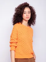 Sweater de tejido de punto color naranja, con diseño de calados, manga larga y cuello redondo.
