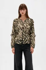 Camisa de poliéster con estampado animal print, cuello en V y volados decorativos en el frente y las mangas.