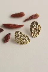 Par de aros colgantes de bronce y alpaca con diseño abstracto calado.