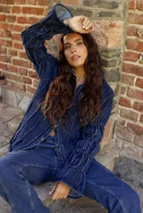 Camisa de jean azul oscuro con cuello mao, cierre frontal con botones metálicos y mangas largas con detalle de frunces elásticos.