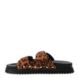 Sandalias planas de mujer Miss Carol Zunna con diseño animal print de leopardo, tiras anchas con hebillas metálicas plateadas de estilo western, tachas decorativas en los laterales y suela negra con plataforma dentada.