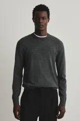 Buzo de punto fino confeccionado en lana merino, color gris oscuro. Presenta cuello redondo, mangas largas y terminaciones acanaladas en cuello, puños y bajo. Posee un corte regular fit para una silueta clásica.