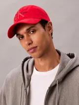 Gorra de béisbol roja con visera curva y cierre ajustable en la parte trasera. Presenta el logo de Calvin Klein bordado en relieve en el panel frontal.