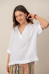Blusa blanca de lino de manga larga con cuello en V y calce holgado.