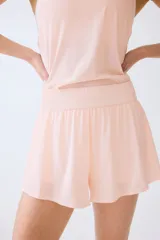 Pantalón corto de deporte de doble capa, color rosado, con corte estándar, cintura elástica fruncida y mallas interiores.