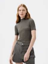 Blusa violeta de tejido de punto acanalado, con cuello alto y mangas cortas.