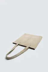 Bolso tipo shopper fabricado en cuero con acabado serraje color gris oscuro. Compartimento principal sin cierre con bolsillo interior con cremallera. Dos asas de mano fabricadas en cuero.