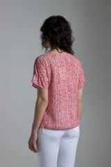 Blusa estampada fucsia y beige con cuello redondo y mangas cortas con volados.