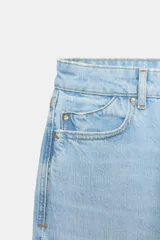 Pantalón jeans Z1975 de tiro alto y diseño mom fit, color azul claro con lavado desgastado, de corte tobillero y cinco bolsillos. Cierre frontal con cremallera y botón metálico.