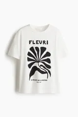 Remera de algodón de corte holgado con cuello redondo y diseño estampado en el frente con la palabra Fleuri y un motivo botánico abstracto.