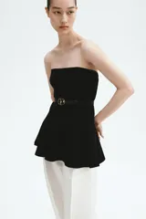 Top strapless largo en punto tupido color negro, con costuras enlazadas y peplum acampanado.