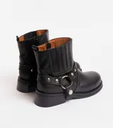 Bota corta negra de cuero vacuno con estribo desmontable, suela de caucho, cierre interno y punta redonda.