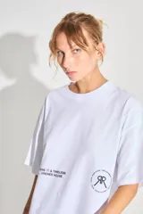 Remerón de corte oversized confeccionado en algodón, con cuello redondo y mangas cortas. Presenta estampados gráficos en color negro en la parte frontal.