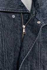 Cazadora corta de denim con efecto lavado, cuello solapa amplio, manga larga y cierre frontal cruzado con botones a presión. Presenta bolsillos laterales de vivo.
