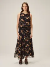 Falda larga azul marino de tejido satinado, con detalle de aplique floral en la cintura.
