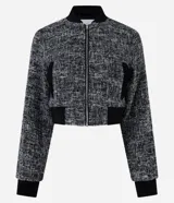 Campera bomber corta confeccionada en tweed con cuello alto, cierre frontal con cremallera, bolsillos y detalles en rib.