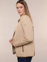Campera matelaseada Michael Kors, de color beige con ribetes de ecocuero marrón. Cuenta con cuello con solapa, cierre frontal con broches metálicos, bolsillos laterales con cierre y mangas largas.