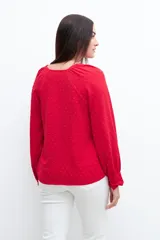 Blusa roja con textura de lunares, escote en V y mangas largas abullonadas.