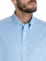 Camisa de manga larga con estampado de cuadros vichy en tonos blanco y celeste. Presenta cuello button-down, cierre frontal con botones, bolsillo en el pecho con logo bordado y puños ajustables con botones.