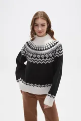 Sweater de punto con diseño jacquard en cuello, puños y ruedo. Presenta cuello alto, mangas largas y corte holgado.