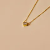 Gargantilla dorada con dije de corazón con circonia transparente.