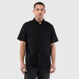 Camisa de manga corta con cuello clásico, cierre frontal de botones y un bolsillo en el pecho. Presenta un diseño de corte regular con textura natural.