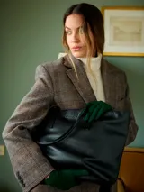 Cartera shopper de gran tamaño, confeccionada en cuero graneado negro, con cierre principal, asas finas y bolsillos interiores.
