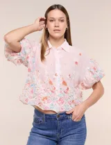 Camisa de gasa rosa con estampado floral y bordados, cuello camisero, mangas cortas abullonadas y cierre frontal de botones.
