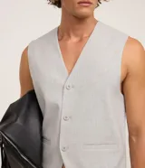 Chaleco gris de poliéster y viscosa, con cuello en V, abotonado delantero y bolsillos decorativos.