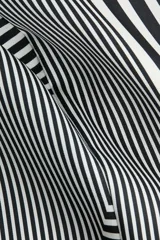 Pantalón de satén fluido color blanco y negro con estampado geométrico de líneas concéntricas, cintura elástica y piernas anchas.