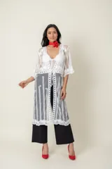 Túnica blanca de tul bordada en hilo, con mangas cortas y terminación de blonda bordada.