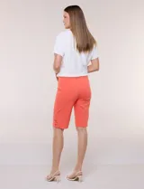 Bermuda entallada color naranja, de corte clásico tipo sastrero, con pretina ancha elastizada y detalles de herrajes en el ruedo.