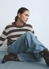 Pantalón de jean estilo wide leg con tiro alto, cierre de botón y cremallera, diseño de cinco bolsillos y trabillas para cinturón.